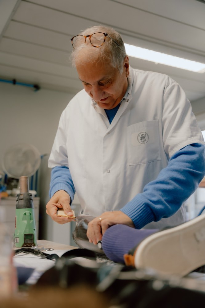 Un prothésiste de l'INI ajuste une prothèse de jambe chaussée dans l'atelier d'appareillage