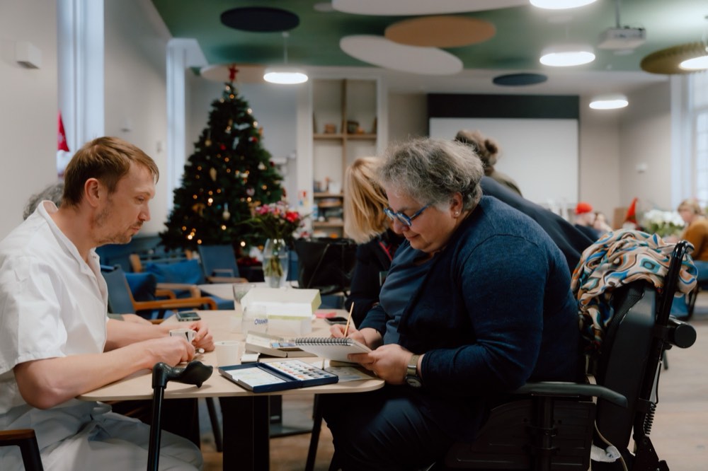 Un pensionnaire et une animatrice peignent à l'aquarelle dans le foyer de vie de l'INI