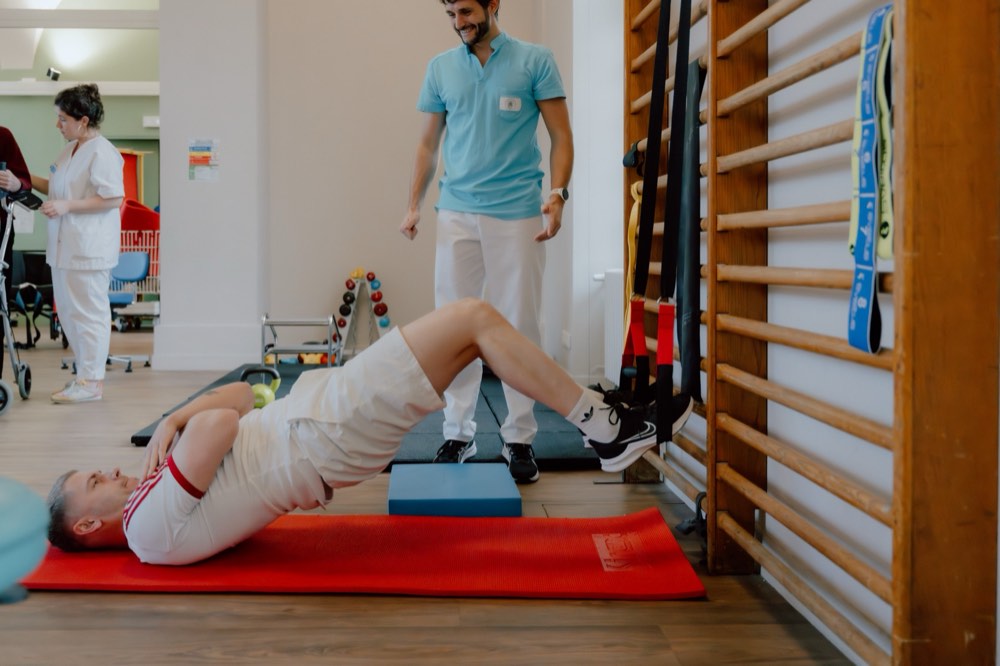 Patient réalisant un exercice de gainage encadré par un kinésithérapeute au CRPT